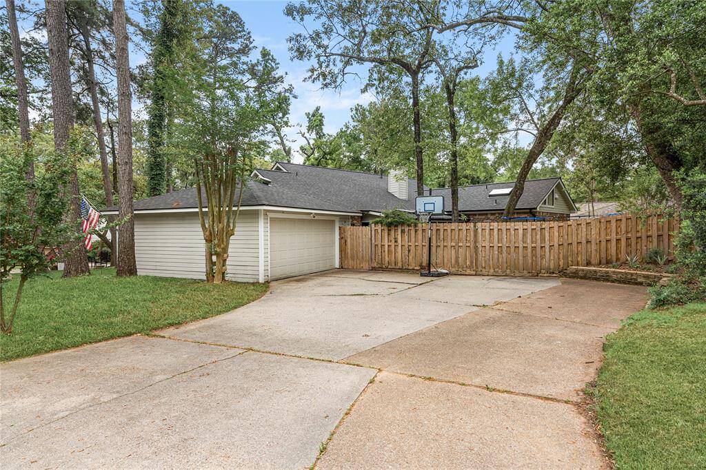 An extra-wide driveway provides ample parking for multiple vehicles, complemented by a detached two-car garage with covered walkway to your back door for added convenience.