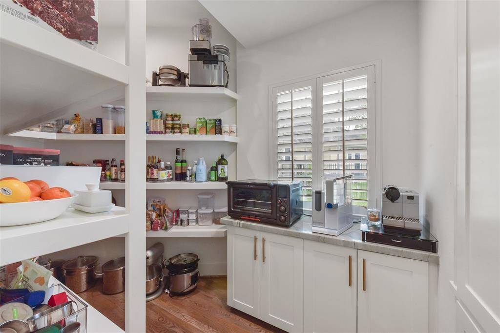 Custom pantry with built-in shelving and counter for appliances.