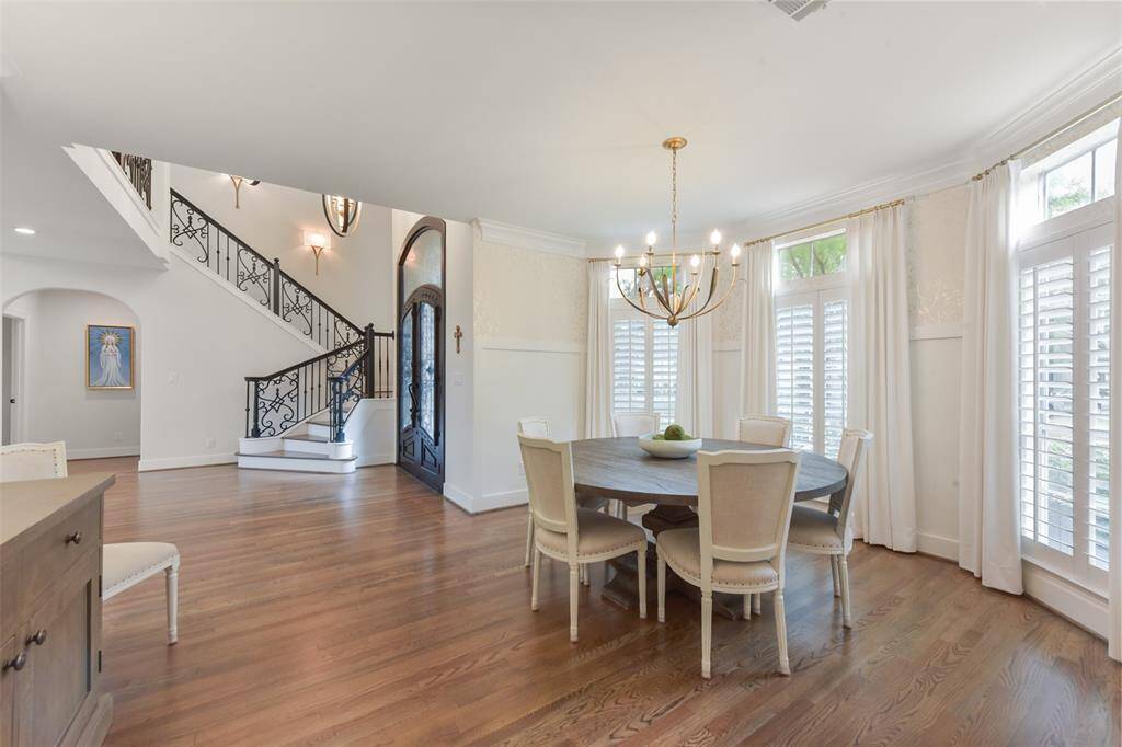 Formal dining room opens to the grand foyer and features designer wall paper as well as plantation shutters and a beautiful upgraded chandelier.