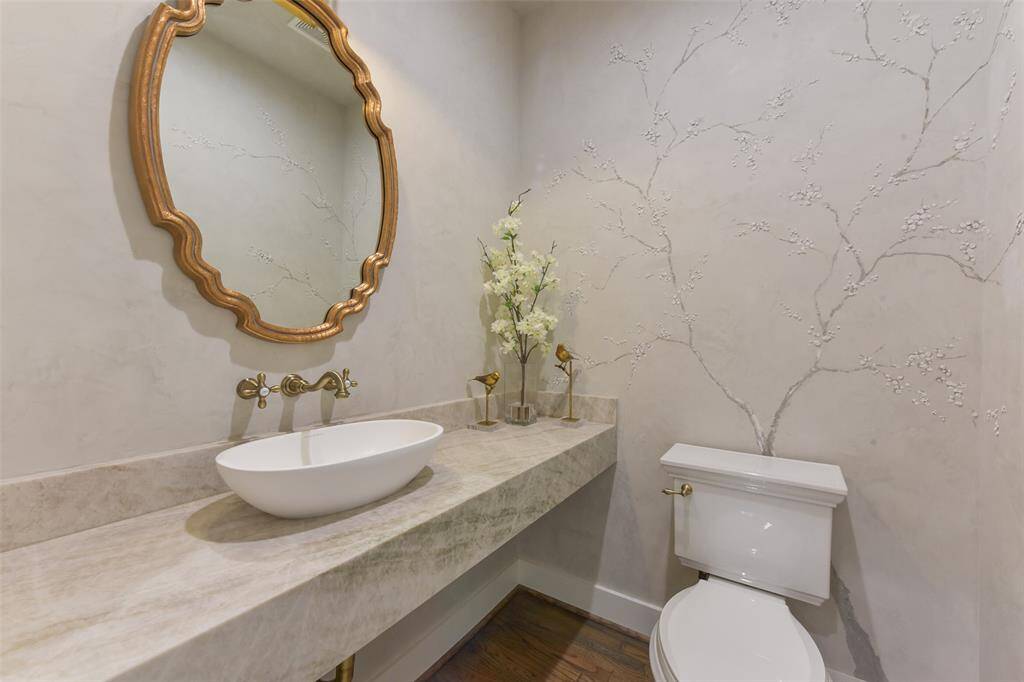 Elegant powder bathroom features upgrades throughout including Venetian plaster artwork.