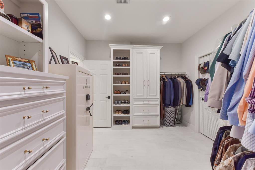 Large dual closets with custom cabinetry in primary suite.