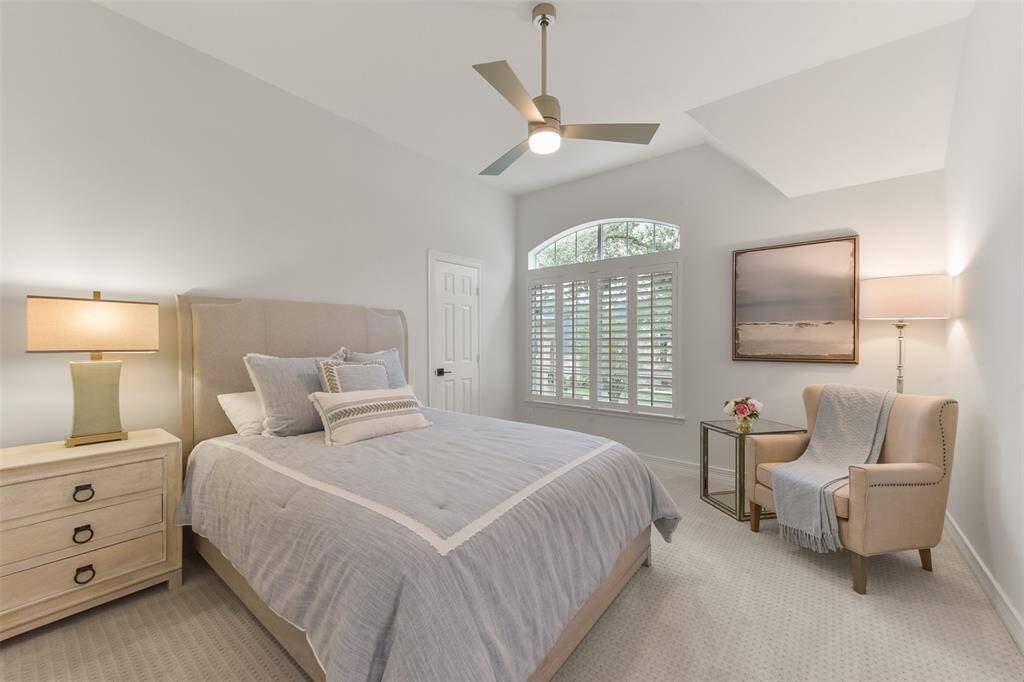 Guest room has plantation shutter and plush carpet. It offers an elegant retreat for long- or short-term visitors.