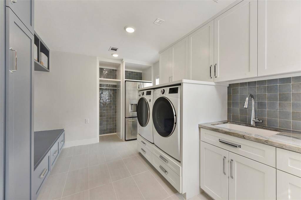 1st floor laundry room offers plenty of storage, custom-built in cabinetry, designer tile, mud area, space for refrigerator and plenty of storage.