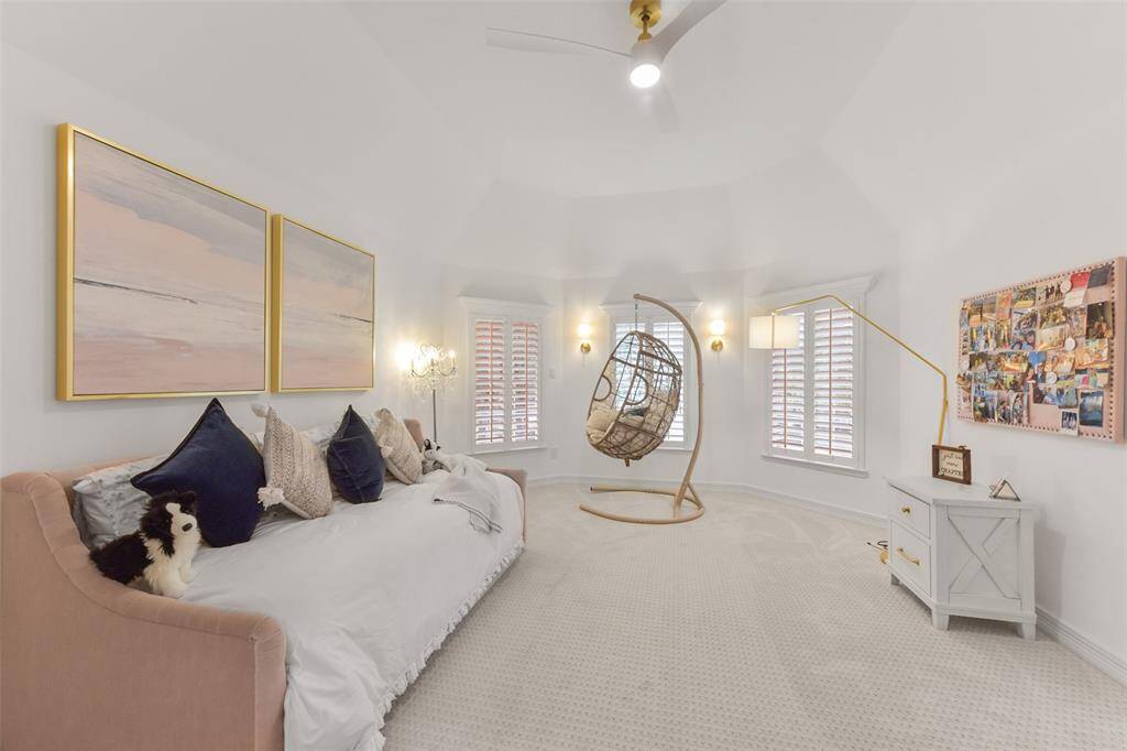Large upstairs bedroom suite features plantation shutters, updated ceiling fan, luxurious plush carpeting, and generously sized closet and private bath.