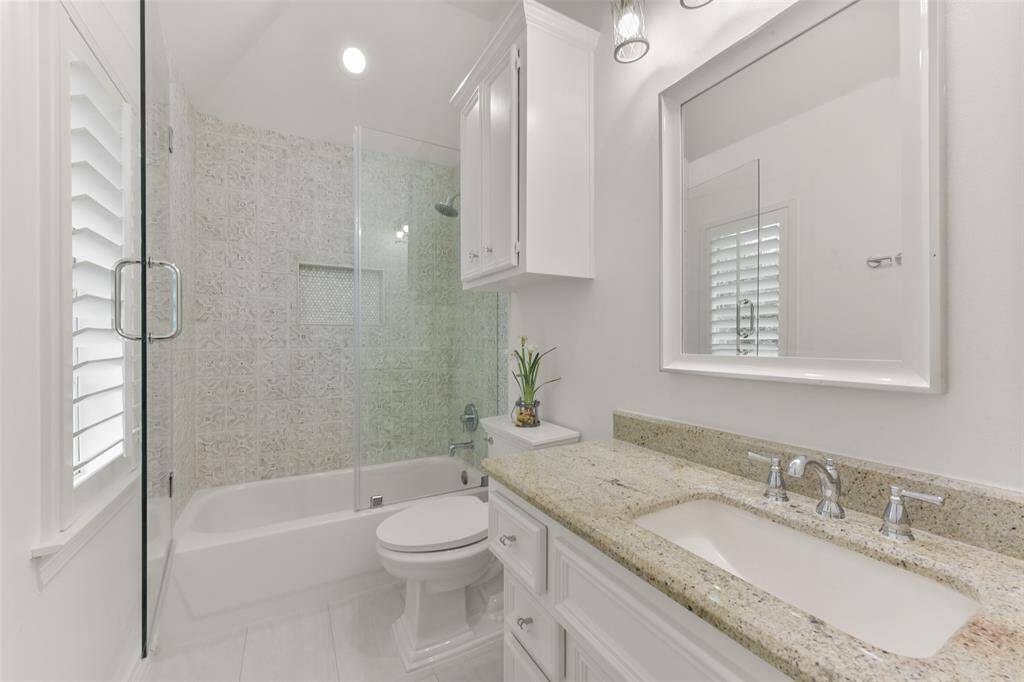 Updated secondary bathroom has designer tile and a glass enclosed tub/shower.