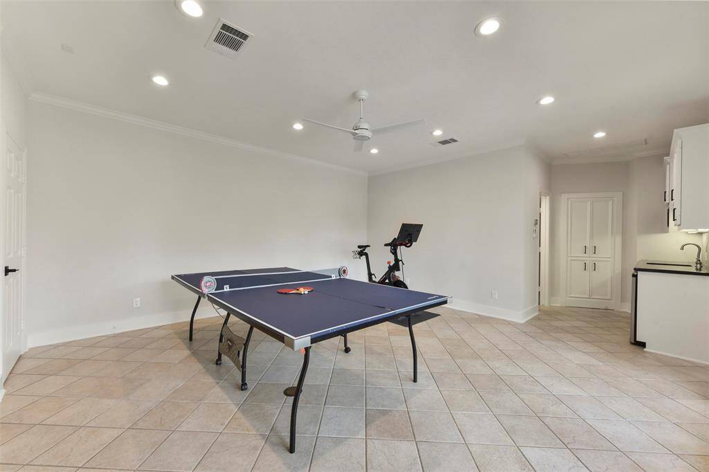Downstairs gameroom offers tile floors and full bath that leads to the pool.