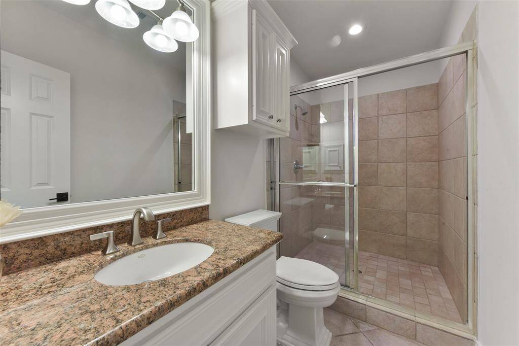 Full bathroom leading to pool keeps your home dry when swimmers are coming and going.