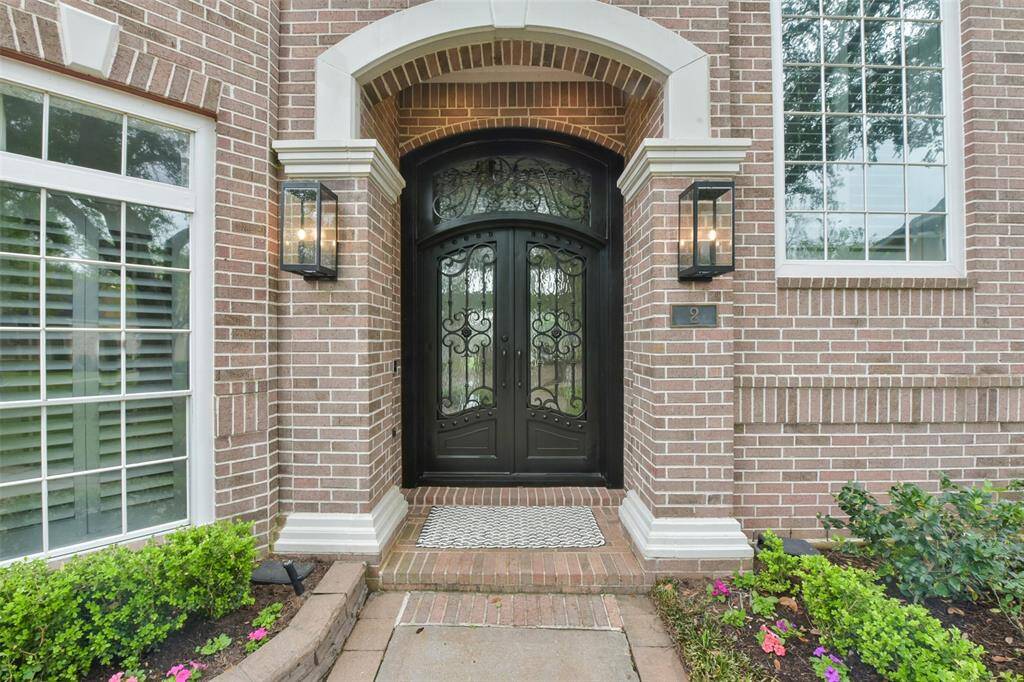 The large, covered entrance features double doors with wrought iron and glass accents (refinished in 2025).