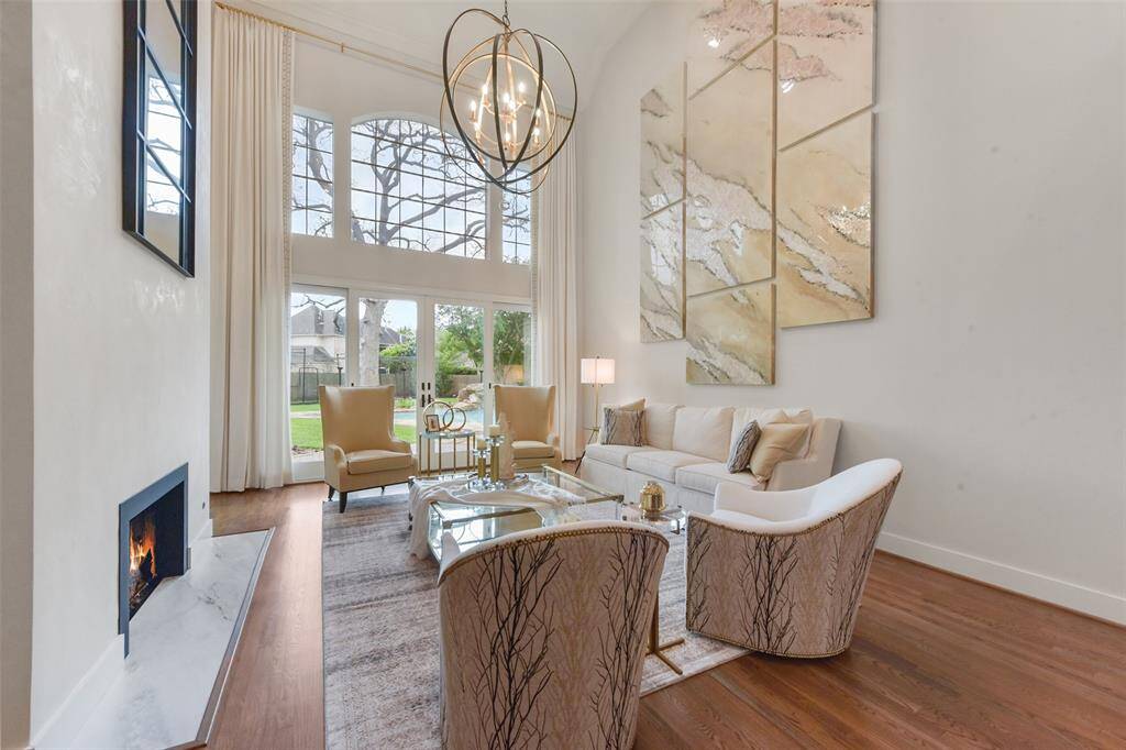 The award winning living room offers high ceilings, wood floors, a venetian plaster double fireplace and updates throughout. The open floor plan opens to a wall of windows overlooking the resort-like backyard.