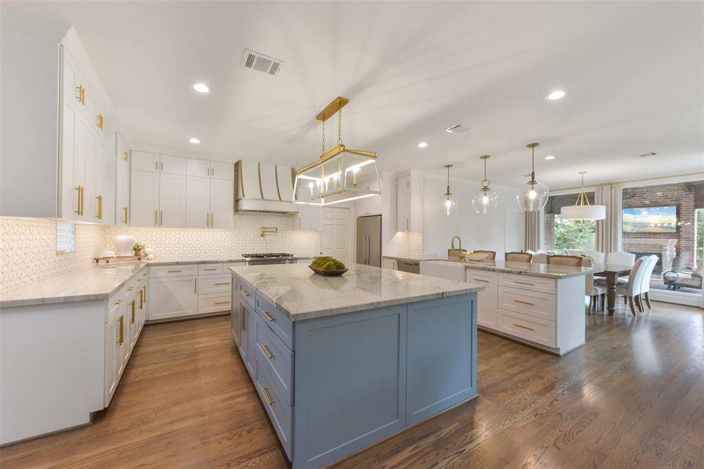 Stunning, award-winning  kitchen features top-of-the-line Fisher & Paykel appliances, including a built-in refrigerator, sleek cooktop, double ovens, warming drawer, and microwave.