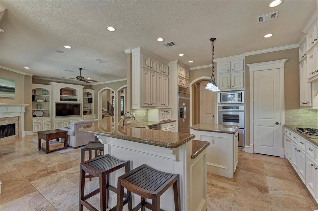 Kitchen features a built-in refrigerator, double ovens and breakfast bar opening to den!