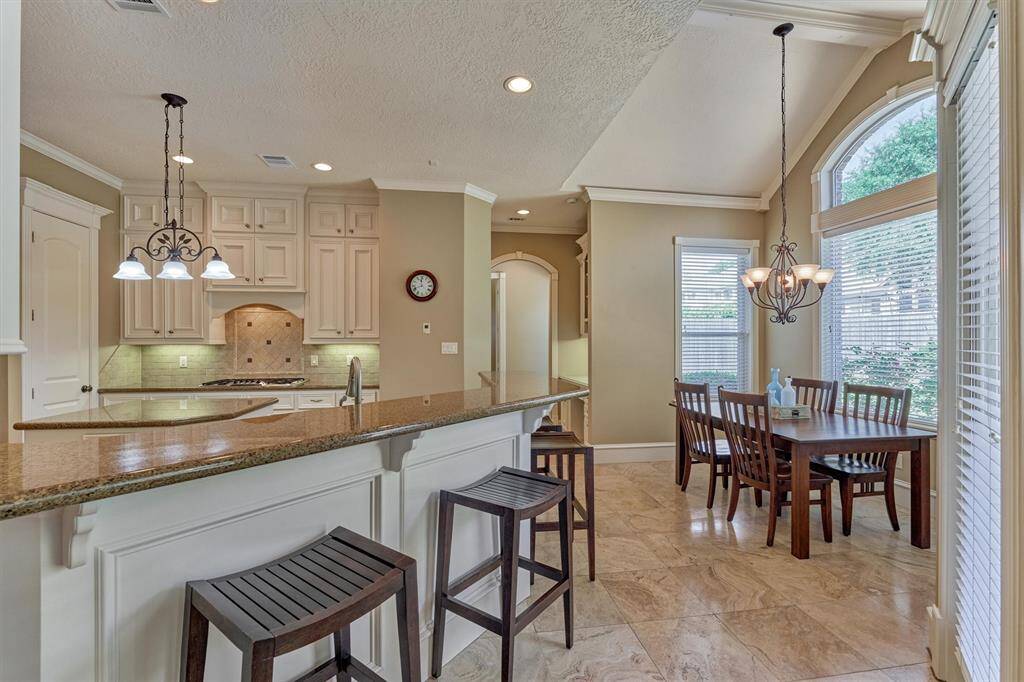 Kitchen opens to the adjoining den and breakfast room with vaulted ceiling and superb views of the tranquil backyard oasis!