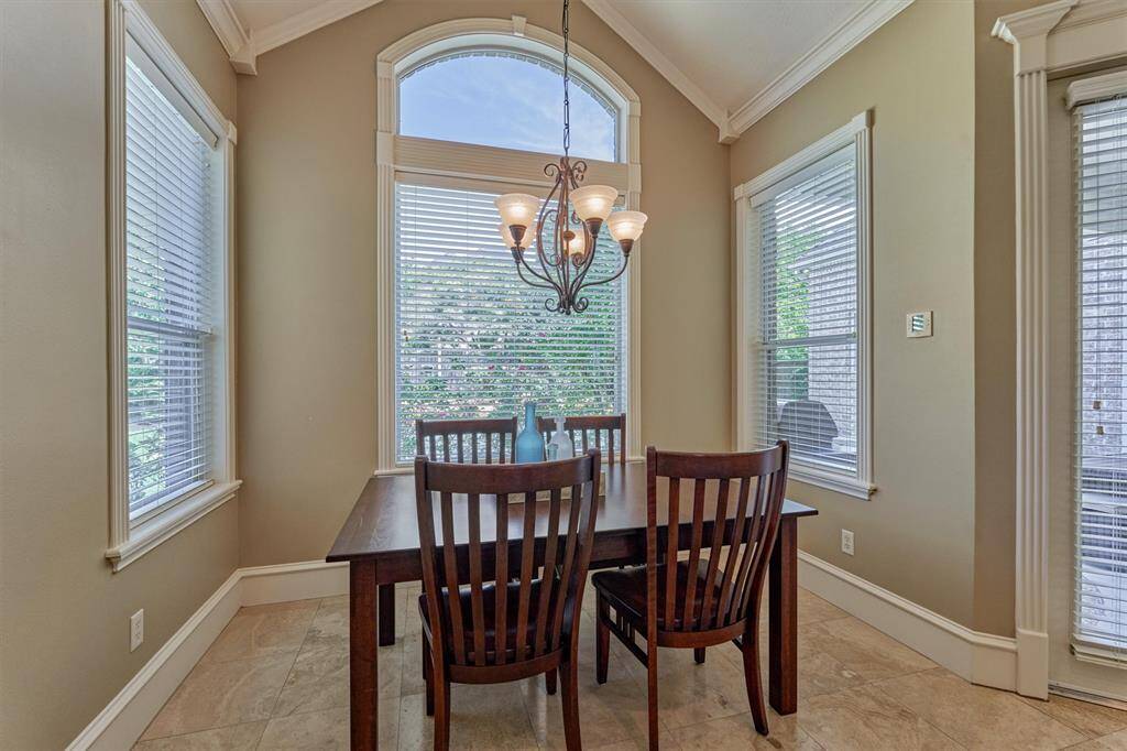 The breakfast room features a vaulted ceiling and beautiful views of the covered back patio and sparkling pool and spa!