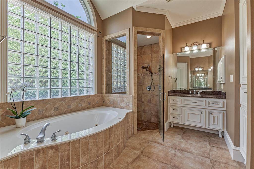 Spa-like primary bathroom boasts a soaking tub, separate walk-in shower, and dual sinks.