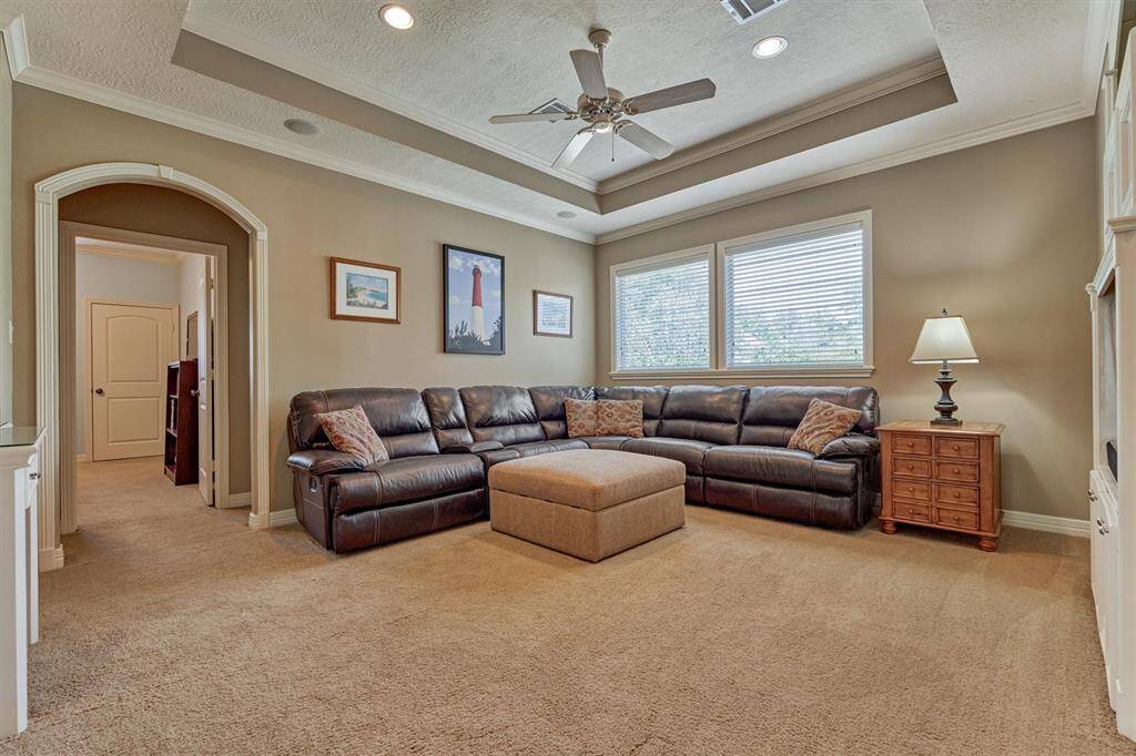 Game room upstairs is spacious and showcases a trayed ceiling and arched doorways.