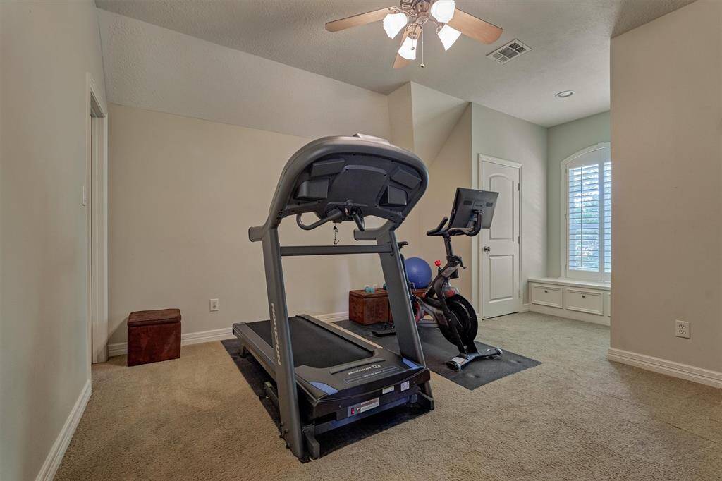 Secondary bedroom #5 is a spacious en suite with walk-in closet, built-in window bench, and plantation shutters.
