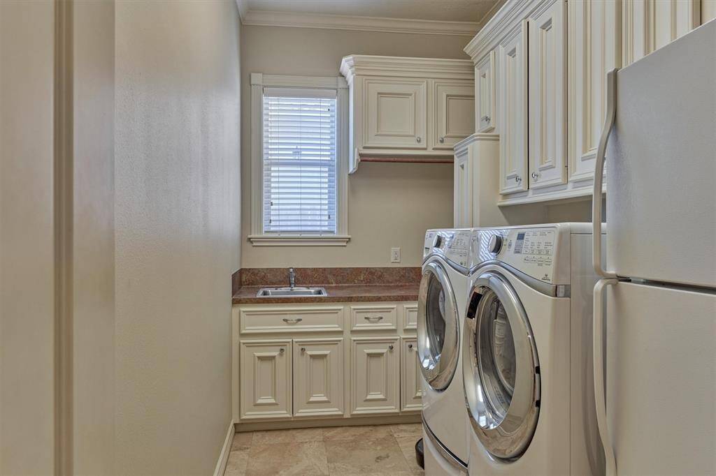 Utility room with sink and tons of cabinetry for extra storage space!