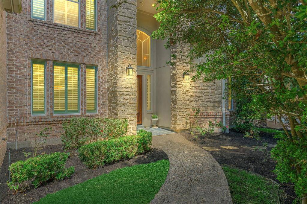 Walking path up to the front entry with brick and stone exterior.