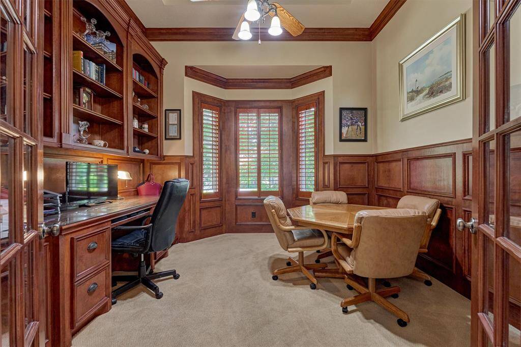 The handsome paneled study is enclosed with French doors boasting built-ins and a bay window.