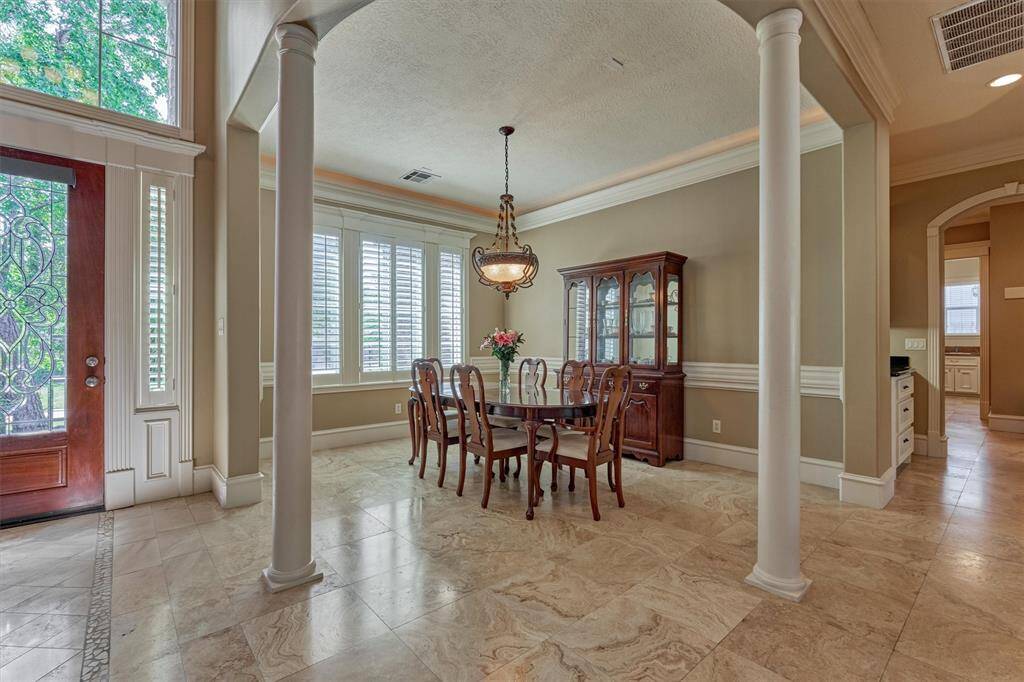 Open formal dining room is flanked with pillars and boasts wraparound molding and plantation shutters. Imagine entertaining family and friends in this gorgeous space!