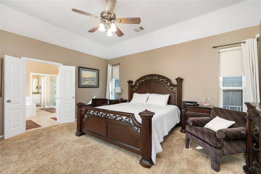 With its high ceiling and expansive layout, this primary bedroom offers a true sense of retreat. Large windows bring in soft natural light, while double doors lead to a private ensuite bath. The tranquil atmosphere and thoughtful design make this an ideal space to unwind and recharge.