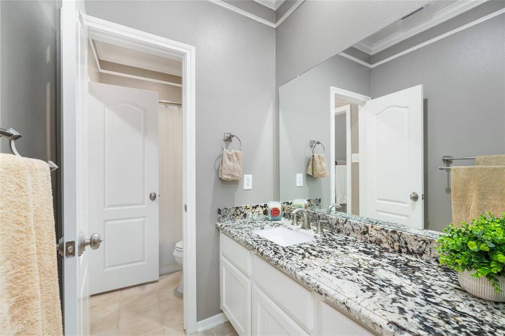 Designed with convenience in mind, this Jack & Jill bathroom connects two bedrooms with a modern layout that includes a granite vanity, neutral tile flooring, and a private toilet area with natural light. A smart, shared setup that blends style and everyday ease.