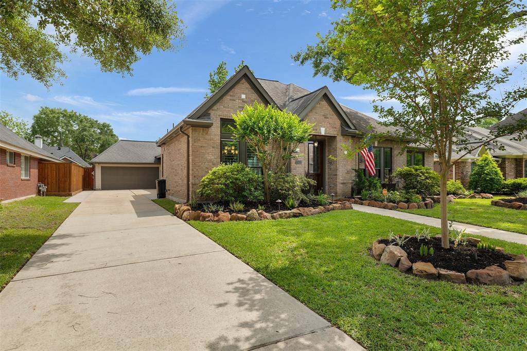 This charming brick home boasts a beautifully maintained front yard with lush greenery and a welcoming pathway to the entrance. The extended driveway leads to a detached garage, providing ample parking and extra space, perfect for those seeking both convenience and a cozy neighborhood feel.