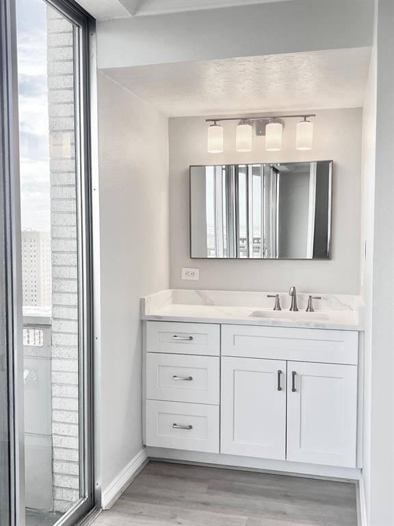 Living room with a view toward vanity, bedroom nook, kitchen, and entry