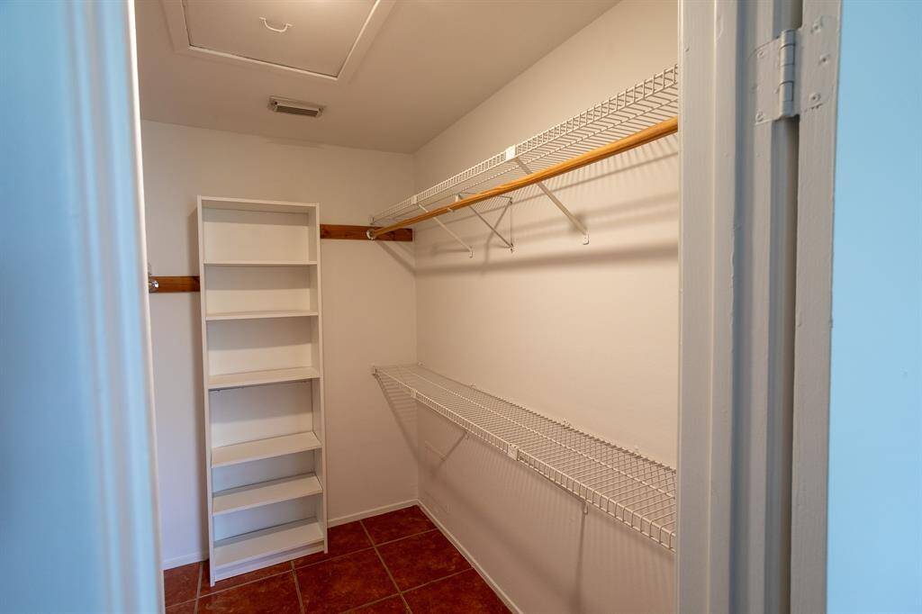 walk in closet in bedroom with built in shelves