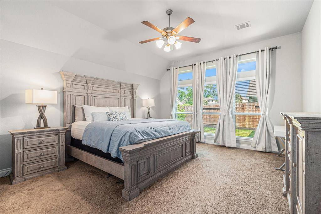 Primary Bedroom features a wall of windows with backyard views.