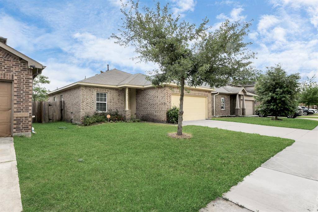 Charming single-story home with a brick exterior and a two-car garage. Features a well-maintained front lawn and a cozy porch area, ideal for a welcoming entrance.