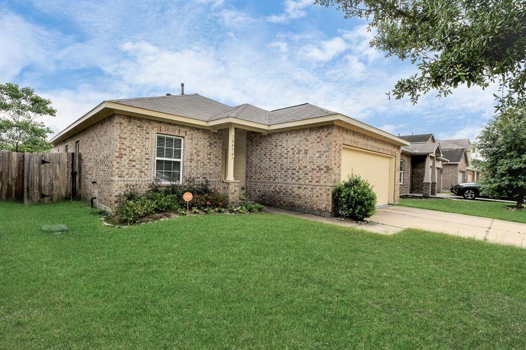Charming single-story home with a brick exterior and a two-car garage. Features a well-maintained front lawn and a cozy porch area, ideal for a welcoming entrance.