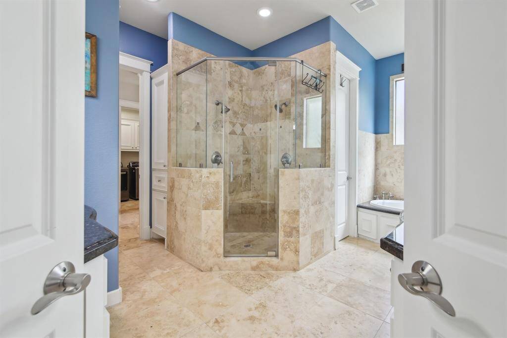 The luxurious primary bath is thoughtfully designed for both comfort and functionality.