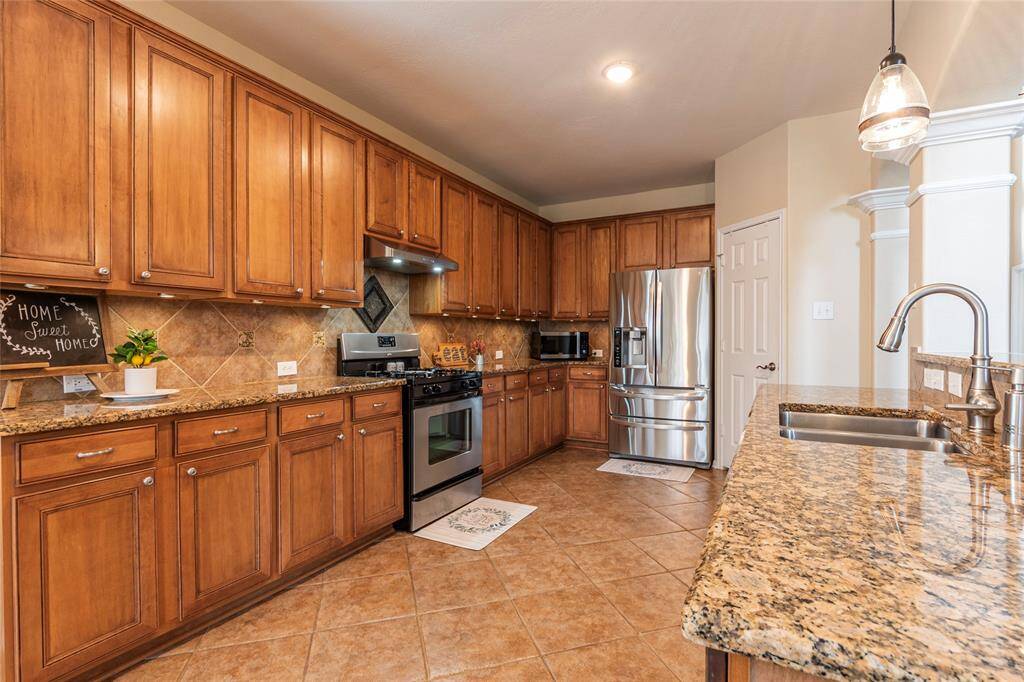 Undermount kitchen sink with upscale touch-less faucet; a closer look at the gorgeous granite counter tops and wood cabinets.