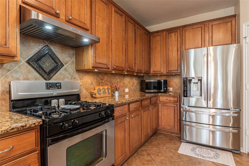 Stainless steel gas range with upgraded overhead vent; undermount cabinet lighting too.