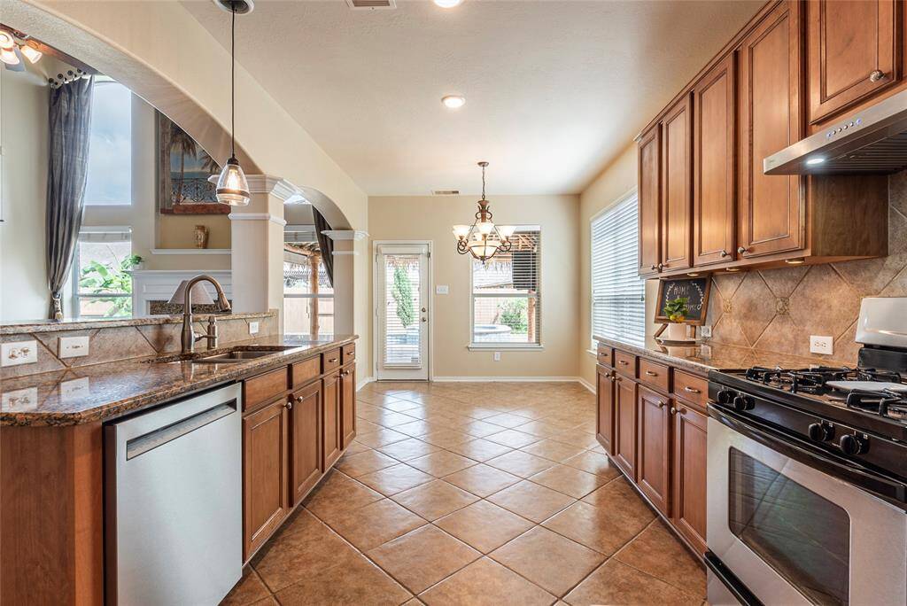 Kitchen is open to the large breakfast area with direct access to the back covered patio and pool.