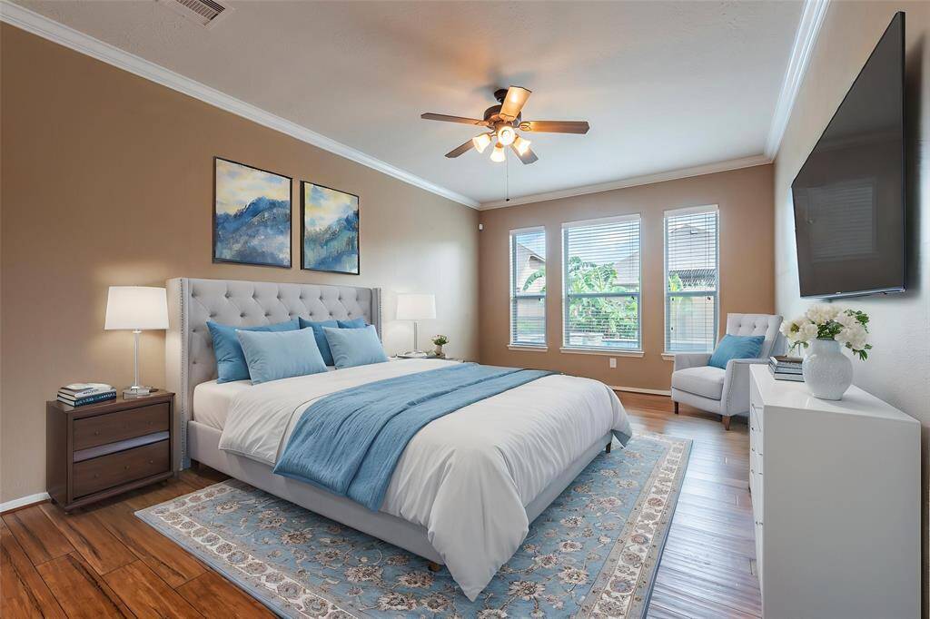 Primary bedroom with bamboo flooring, crown molding, 2" blinds, high ceilings and pool views. Virtually staged.