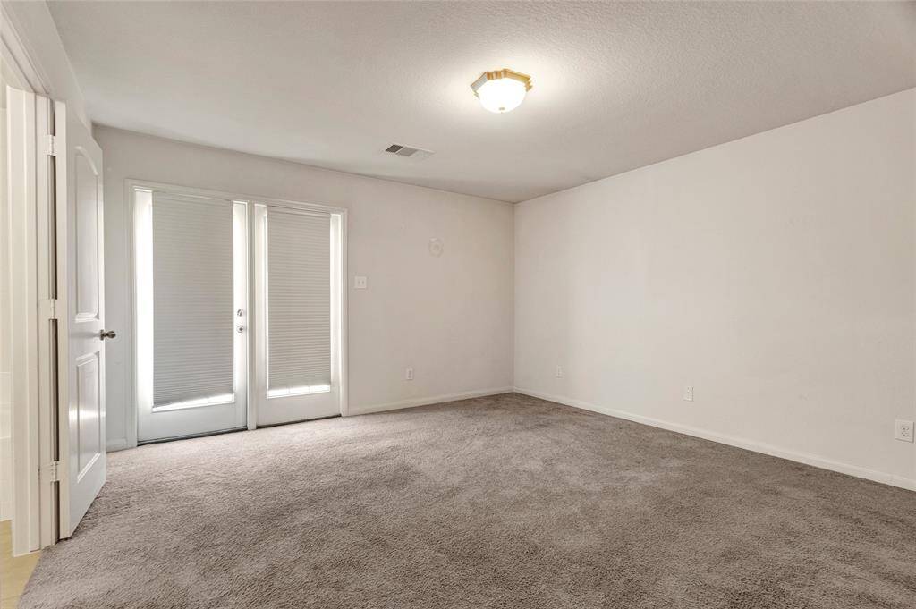 Large primary bedroom with French doors leading to back yard.