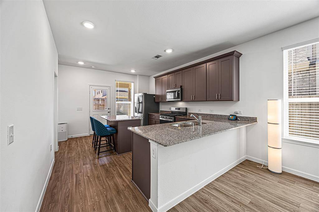 This open-concept kitchen includes a granite bar that overlooks the living room.