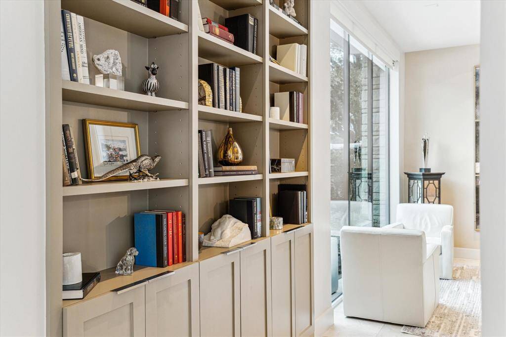Wall of bookcases is located between living room and dining room. The guest bath is located in the same hallway.