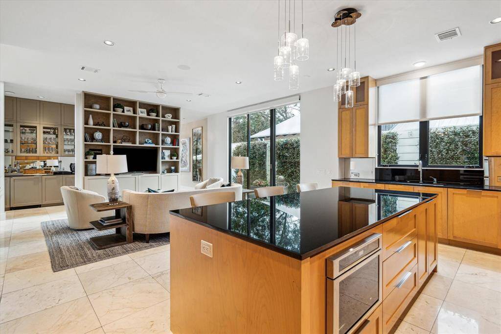 Kitchen and family room showing the open floor plan and views of the side patio. Convenient access to the attached 2 car garage from here.