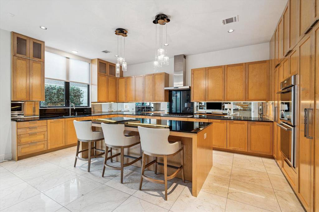 Kitchen features soft close pot and pan drawers, soft close cabinet doors, undercounter lighting, granite slab counters and backsplash. Themador appliances. Appliance garage.