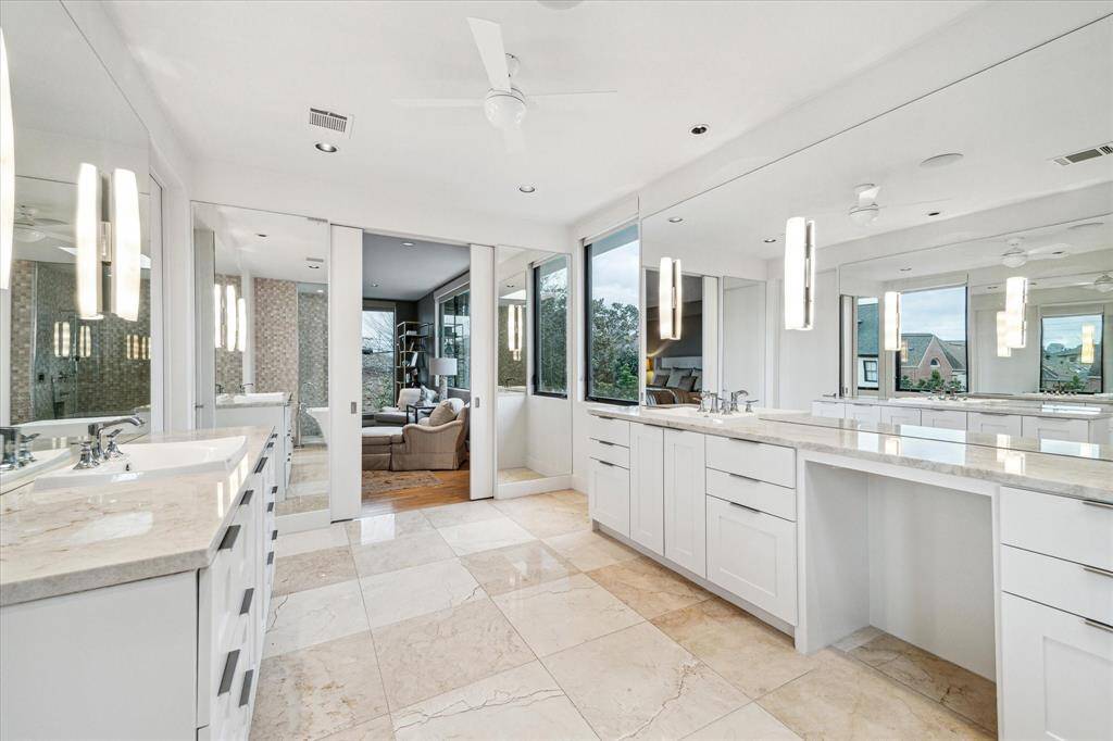 Primary bath - Carrera marble floors, Custom tile work Double sinks and vanities. Lots of natural light coming in..