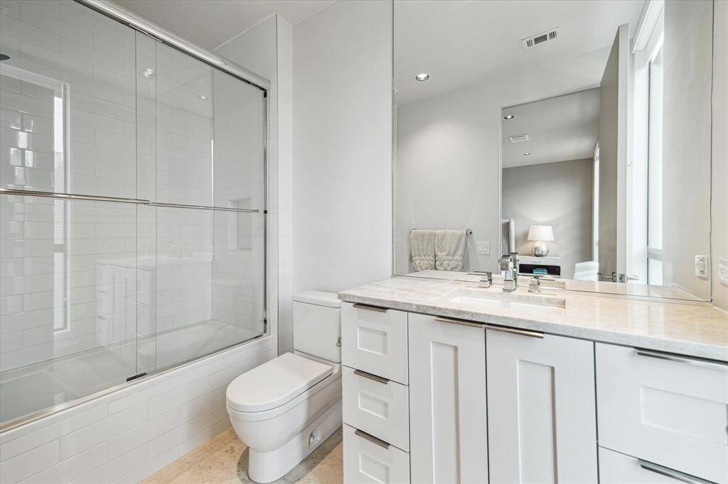 Second Bedroom Ensuite Bath - Carrera marble flooring. Custom tile. Kohler sink. Delta faucets. Stone Slab Countertop.