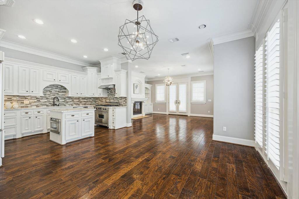Enjoy relaxing on the second-floor covered balcony, located just off the living room. The balcony features a built-in grill, tiled flooring, a ceiling fan, and a wrought iron banister overlooking the backyard, with a staircase leading down to the outdoor space below.