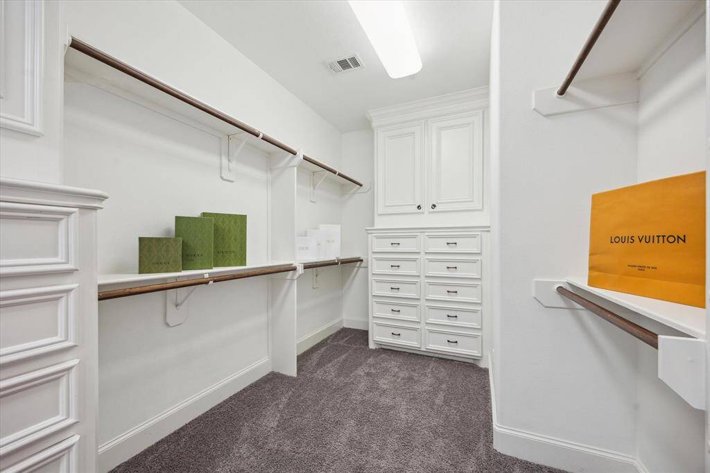 The first-floor bedroom, located off the foyer, features decorative tile flooring, a ceiling fan, large windows , an ensuite bath and walk in closet.