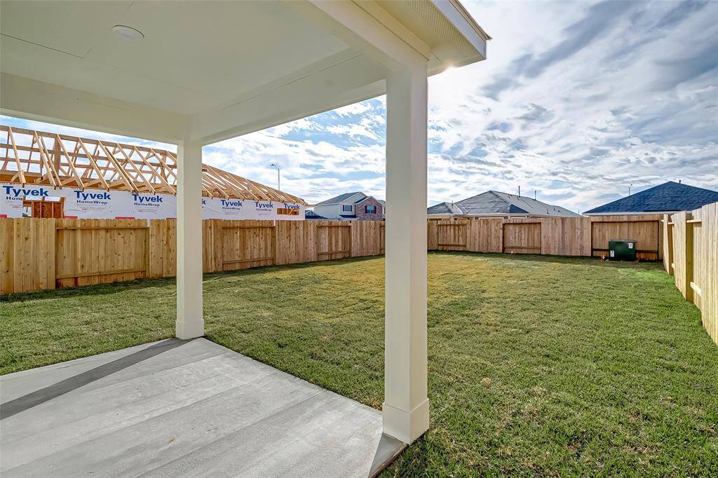 Spacious back yard with covered patio perfect for a seating area