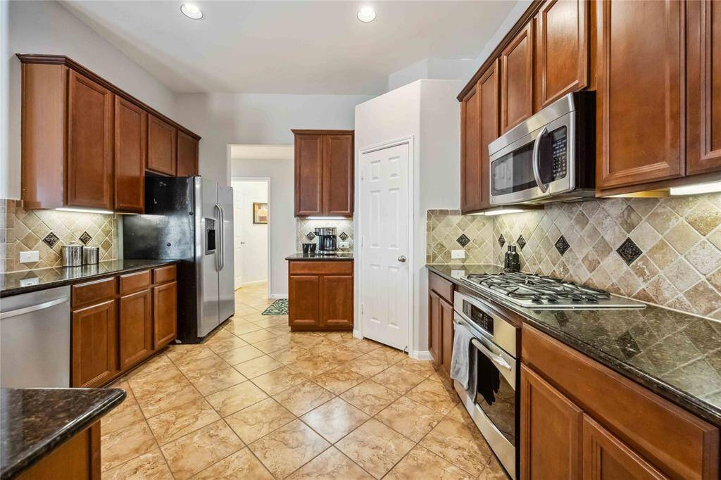 Kitchen offers plenty of counter space and a sink overlooking the living room—great for staying connected while cooking.