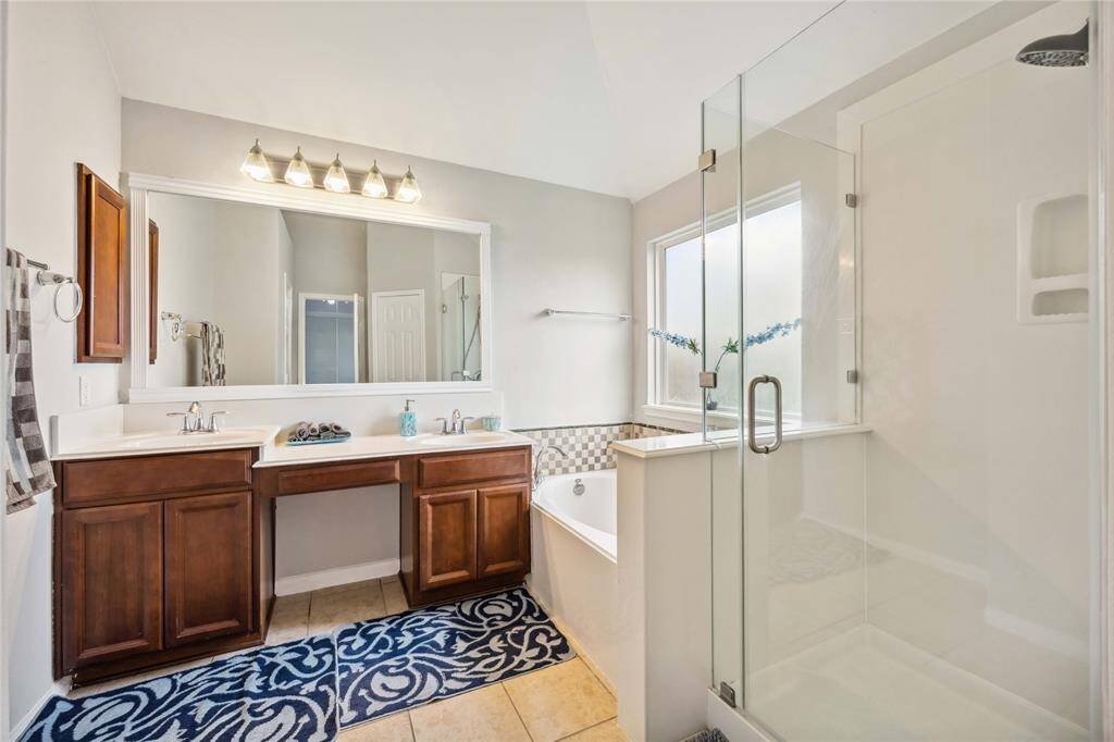 Primary bathroom with double sink, separate bathtub and shower.