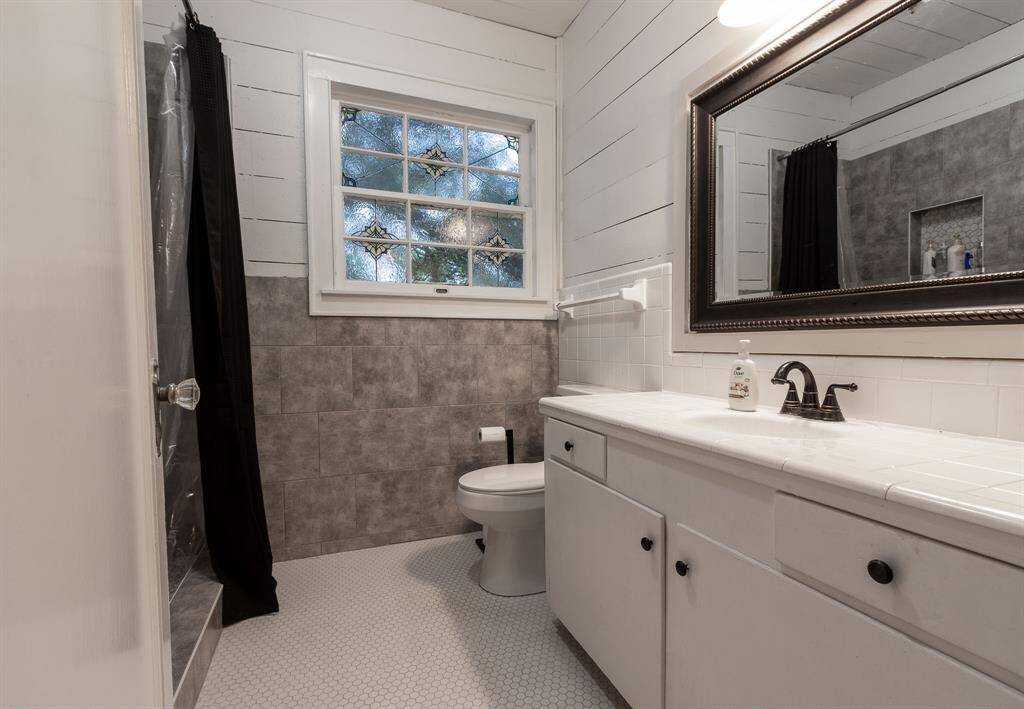 Hall Bathroom with stained glass detail and walk in shower.
